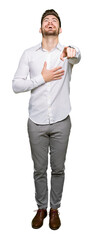 Young handsome business man Laughing of you, pointing to the camera with finger hand over chest, shame expression