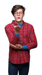 Young handsome man wearing glasses over isolated background looking at the camera blowing a kiss with hand on air being lovely and sexy. Love expression.