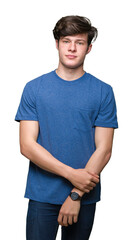 Fototapeta premium Young handsome man wearing blue t-shirt over isolated background Relaxed with serious expression on face. Simple and natural looking at the camera.