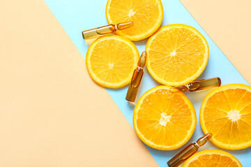 Ampoules with vitamin C and orange slices on colorful background