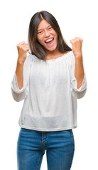 Young asian woman over isolated background very happy and excited doing winner gesture with arms raised, smiling and screaming for success. Celebration concept.