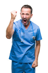 Middle age hoary senior doctor man wearing medical uniform over isolated background angry and mad raising fist frustrated and furious while shouting with anger. Rage and aggressive concept.