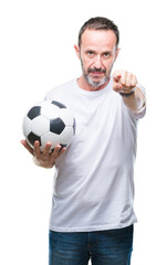 Middle age hoary senior man holding soccer football ball over isolated background pointing with finger to the camera and to you, hand sign, positive and confident gesture from the front