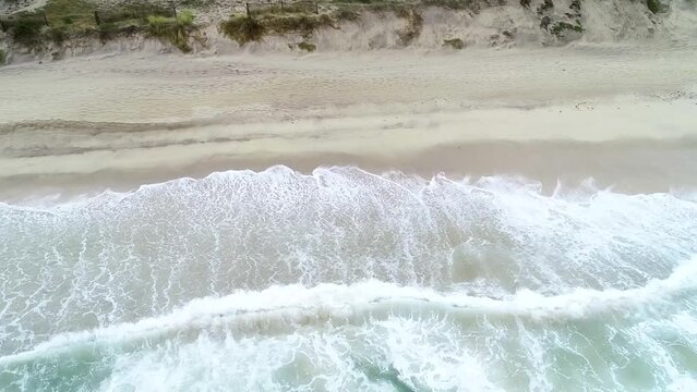 aerial traveling footage with drone over a beach shore