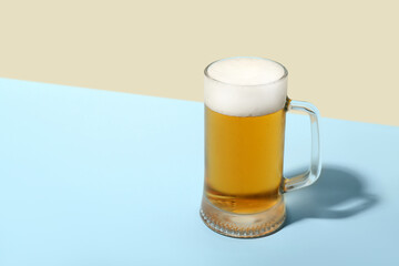 Mug of cold beer on color background