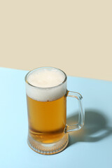 Mug of cold beer on color background