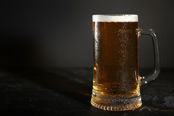 Mug of cold beer on dark background, closeup