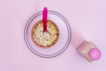 A still life of cereals in a pink bowl