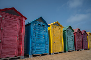 colorful beach huts during summer with blue sky and copy space 