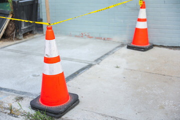 Vibrant orange construction cones line the street, symbolizing progress, caution, and temporary...