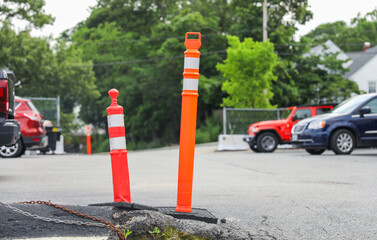 Vibrant orange construction cones line the street, symbolizing progress, caution, and temporary...