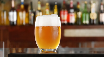 beer served in a glass on a bar with a background of a bar in high resolution. liquor concept in a bar