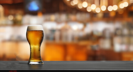 beer served in a glass on a bar with a bar background