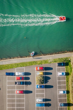 Aerial view of Looe carpark with cars and speed boat on the river, Cornwall, United Kingdom.