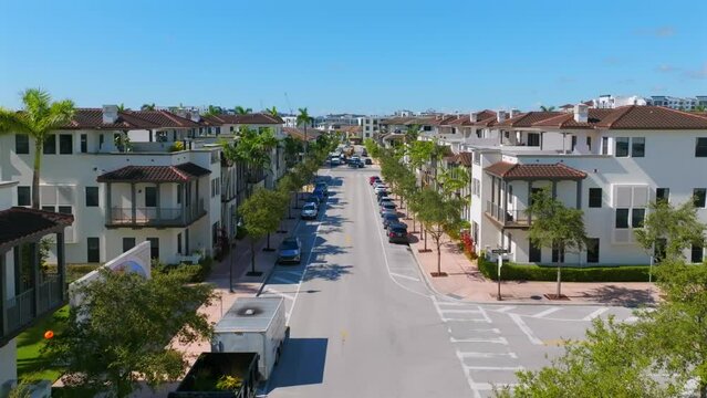 Aerial view of beautiful new contemporary suburban townhouses in american neighborhood on busy street with lots of cars. Brand new houses on real estate market of Miami