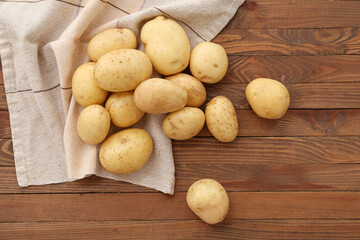 Many raw potatoes on wooden background