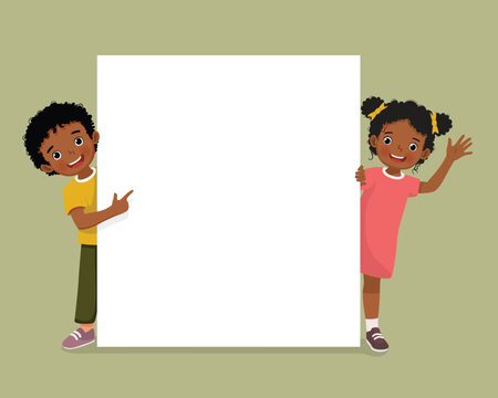 Cute African kids little boy and girl standing behind empty banner peeking and pointing finger over board
