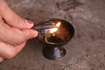 lighting a candle from a lamp