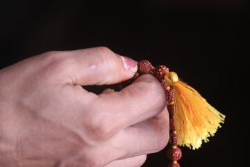 praying hands holding a basil garland 