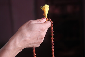 praying hands holding a basil garland 