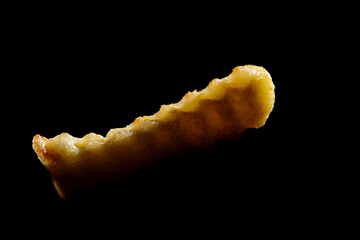 Close up of crinkle fries on black background