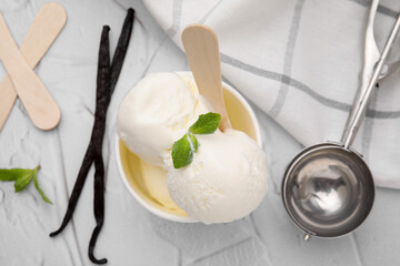 Delicious vanilla ice cream served on white textured table, flat lay