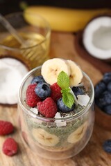 Tasty oatmeal with chia matcha pudding and fruits on wooden table, closeup. Space for text. Healthy breakfast