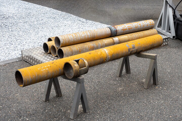 Old pipes. Metal pipeline with traces of rust. Pipe support is installed on asphalt. Concept of...