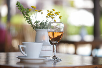 Glass of prosecco and cup of coffee on the table in cafe	