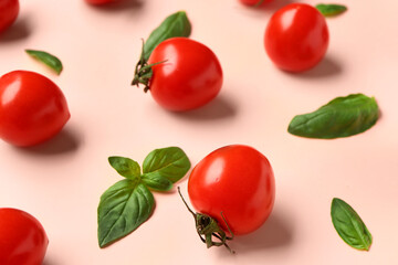 Fresh cherry tomatoes and basil on pink background