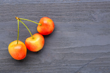 Sweet yellow cherries on blue wooden background
