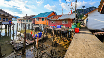 Fototapeta na wymiar Houses on stilts in the floating fishing village of Koh Panyee, suspended over the waters of the Andaman Sea in the Phang Nga Bay, Thailand