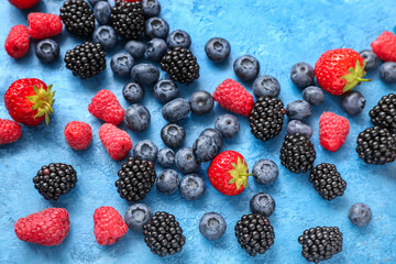 Different fresh berries on blue background, closeup