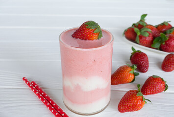 Strawberry yogurt fruit juice smoothie pink colorful fruit juice milkshake blend beverage healthy high protein the taste yummy In glass drink episode morning on white wood background.