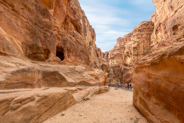 Visitors pass through the canyon ravine on the way to the Treasury building in the ancient...