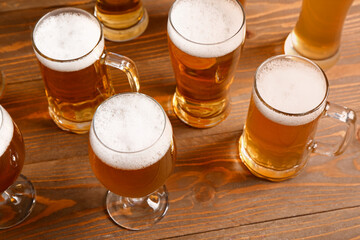Glasses and mugs of cold beer on wooden background. Oktoberfest celebration