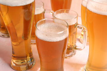 Glasses and mugs of cold beer on beige background. Oktoberfest celebration