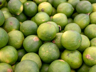 A pile of ripe green baby oranges in the supermarket