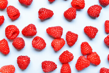 Many fresh raspberries on blue background
