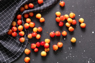 Many sweet yellow cherries on black background