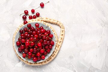 Plate with red sweet cherries on grunge background