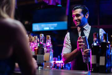 Caucasian profession bartender making a cocktail for women at a bar. 