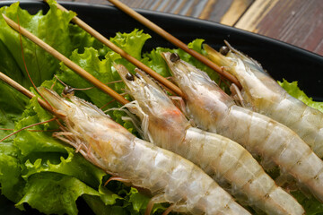 Fresh shrimp skewers on a monochrome background