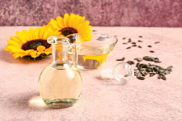 Obraz na płótnie Canvas Decanter of sunflower oil on pink background