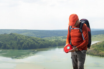 Traveler caucasian man using first aid kit  in the mountains, near lake.