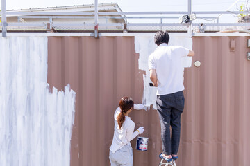 外壁を塗装する男女　Men and women painting the outer wall	