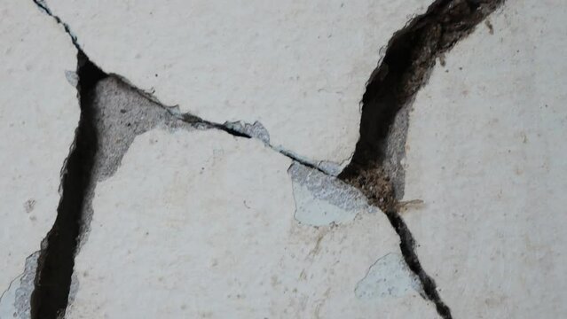 Old concrete wall background with large crack.Grey cement wall surface with large damage.