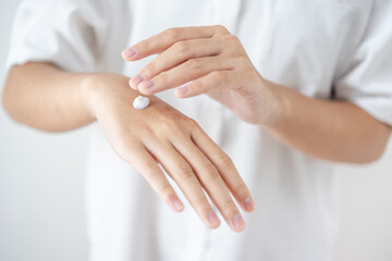 Obraz na płótnie Canvas Asian woman hands applying skin cream on hands and arms for healthy skin.