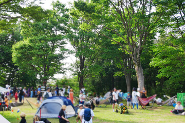 公園にテントやハンモックを張ってくつろぐ人々