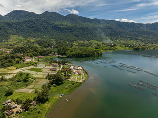 Fototapeta na wymiar Aerial view of farmland and rice fields on the Maninjau lake shore in the mountains. Sumatra, Indonesia.